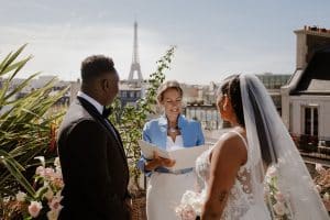 Couple échangeant ses vœux face à son officiante lors d'une cérémonie laïque sur un toit de Paris