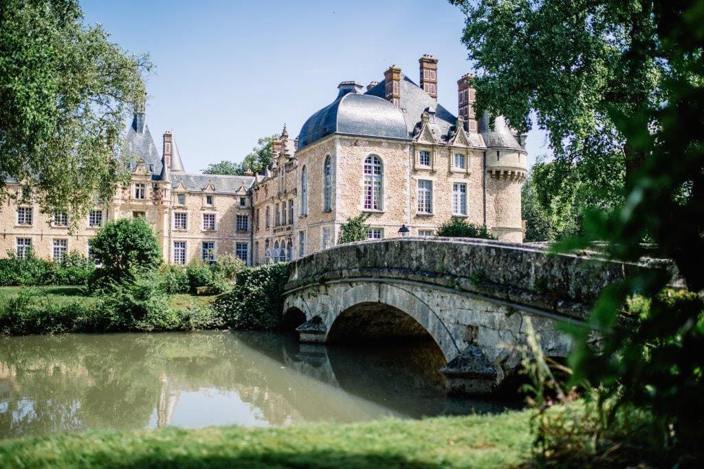 Château élégant en pierre entouré de verdure, cadre romantique idéal pour un mariage.