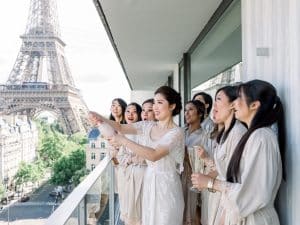 Mariée ouvrant le champagne avec ses demoiselles d'honneur en peignoirs face à la Tour Eiffel